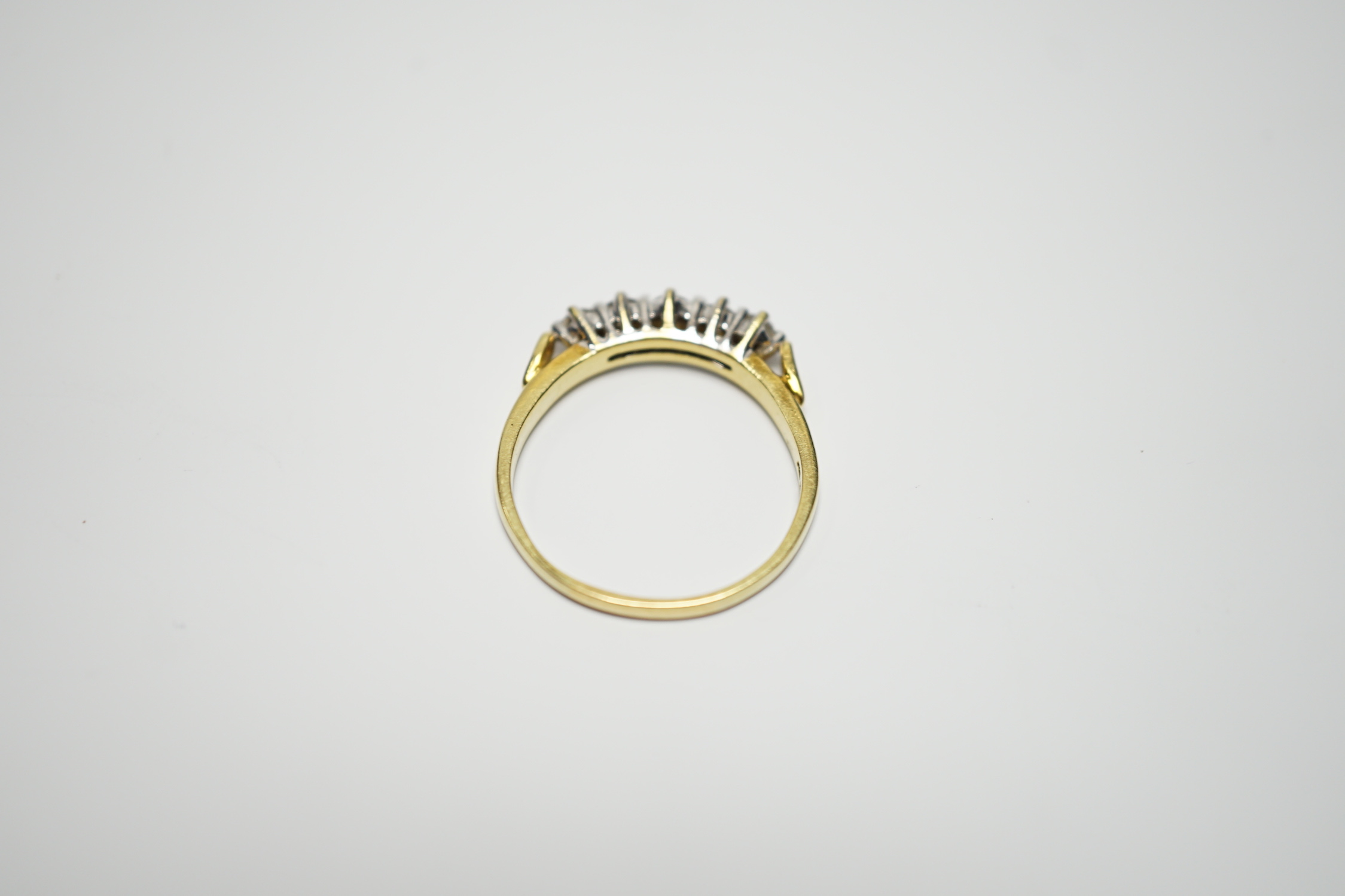 A modern 18ct gold and graduated five stone diamond set half hoop ring, size T, gross weight 4.4 grams.